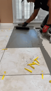 Professional installing porcelain tiles: expert carefully applying tiles to ensure perfect alignment and secure attachment